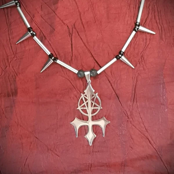 Ce collier unisexe est composé d'un gros pendentif avec croix et pentacle inversé, encadré par des perles en pierre de lave. Le tout est habillé de spikes et de perles en verre noires. L'effet rétro du collier de spikes mis en valeur par un pendentif qui l'est beaucoup moins, voila un collier atypique et de qualité.