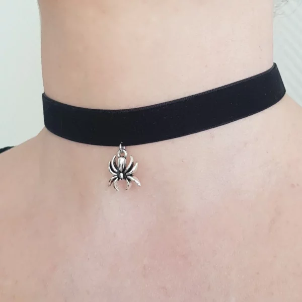 Ce collier ras de cou en velours noir est décoré d'un pendentif petite araignée, couleur argent.