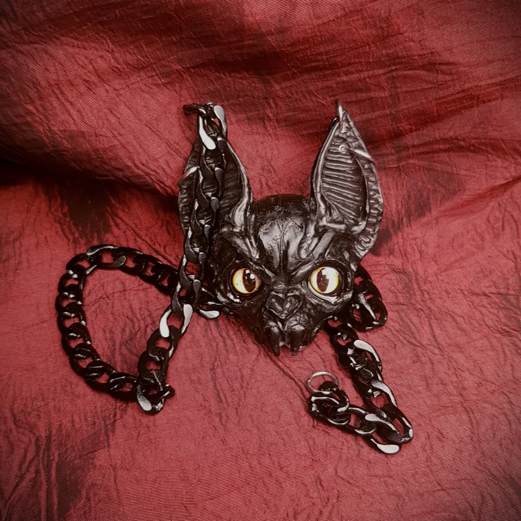 Collier tête de chauve-souris version yeux jaune