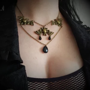 Pour donner à votre look un côté goth/ steampunk, adoptez ce collier chauve-souris! Leur couleur bronze fait magnifiquement ressortir  les perles noires, pour une finition tout en brillance.