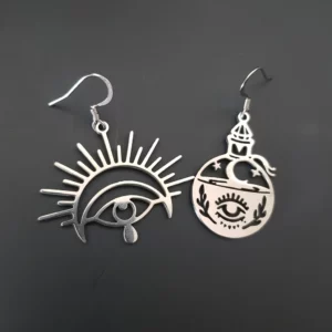 Ces boucles d'oreilles asymétriques Mystique ont tout pour réveiller votre coté spirituel grâce à leurs ornements, grand oeil de la clairvoyance d'un côté et fiole magique avec lune et étoiles de l'autre.