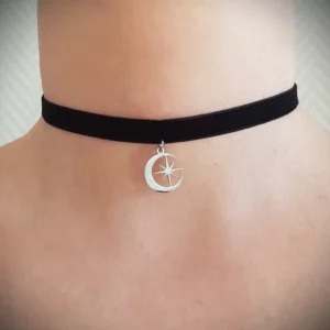 Ce ras de cou lune et étoile se compose d'un pendentif en acier inoxydable, la lune tenant entre ses pointes une délicate étoile, soutenu par un ruban en velours noir. Un bijou minimaliste de qualité tout en finesse.