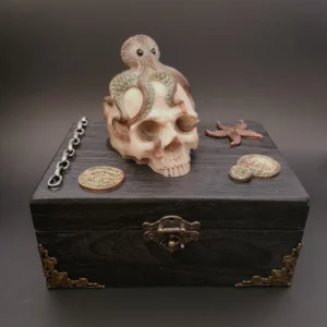 Cette boîte en bois décorée L'âme des pirates est une décoration à elle seule, avec son crâne poulpesque et son décor caché dans le couvercle.