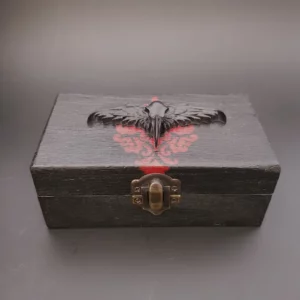 Cette boîte en bois décorée Corbeau, totalement dans le style gothique, alterne entre noir et rouge avec ces motifs baroque en 3D ou peint.