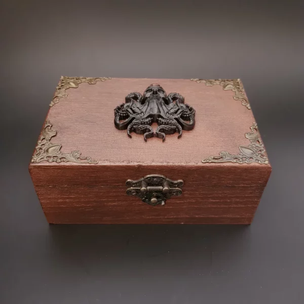 Cette boîte en bois décorée Kraken joue avec des couleurs dans des tons ancien. Et l'on jurerai que l'oeil unique de cette créature vous observe.