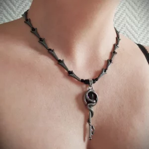Ce collier avec pendentif clef et serpent, composé de perles en hématite et en verre, est orné d'un superbe pendentif en acier inoxydable.