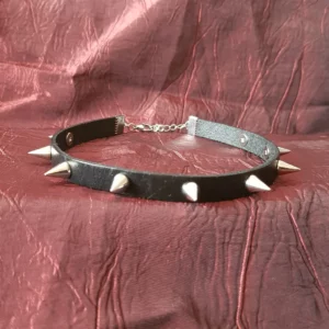 Un grand classique du gothique punk: le collier ras de cou en cuir noir avec piques de couleur, au choix: noir, argenté, rouge ou rose.