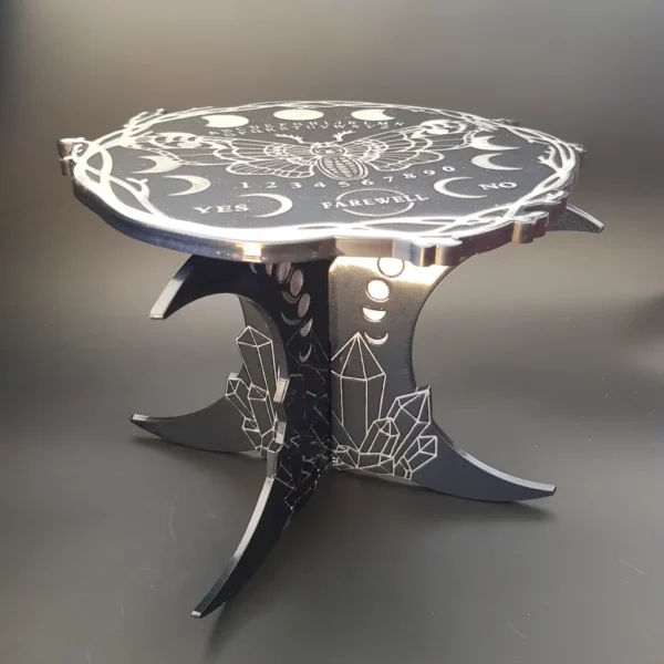 Cette petite table ouija pour plantes et décoration, motif lunes et cristaux vous séduira à coup sûr pour une décoration witchy à souhait.