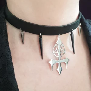 Ce collier en cuir avec croix inversée et pentacle est orné d'un pendentif central croix satanique en acier inoxydable, avec piques noir et acier.
