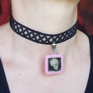 Ce collier gothique lolita tête de mort se compose d'une dentelle noire à motif géométrique accompagné d'un pendentif carré de couleur rose pastel, avec en son centre une tête de mort. Un modèle unique et atypique parfait pour les styles lolita et pastel gothique!
