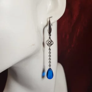 Ces boucles d'oreilles celtique avec perles rouge ou bleu se distinguent par leur finesse et leur long pendant avec finition perle goutte en verre transparent.