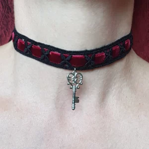 Ce collier tour de cou baroque clef des secrets se compose d'un choker en dentelle noire et velours rouge, orné d'un pendentif clé en acier inoxydable.